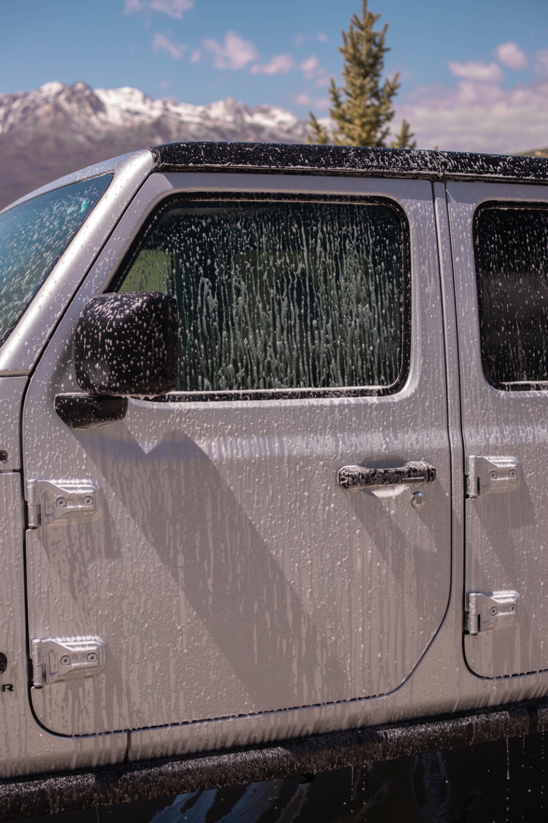 A LivFlo detailer foam-washing a Jeep at a Utah trailhead.