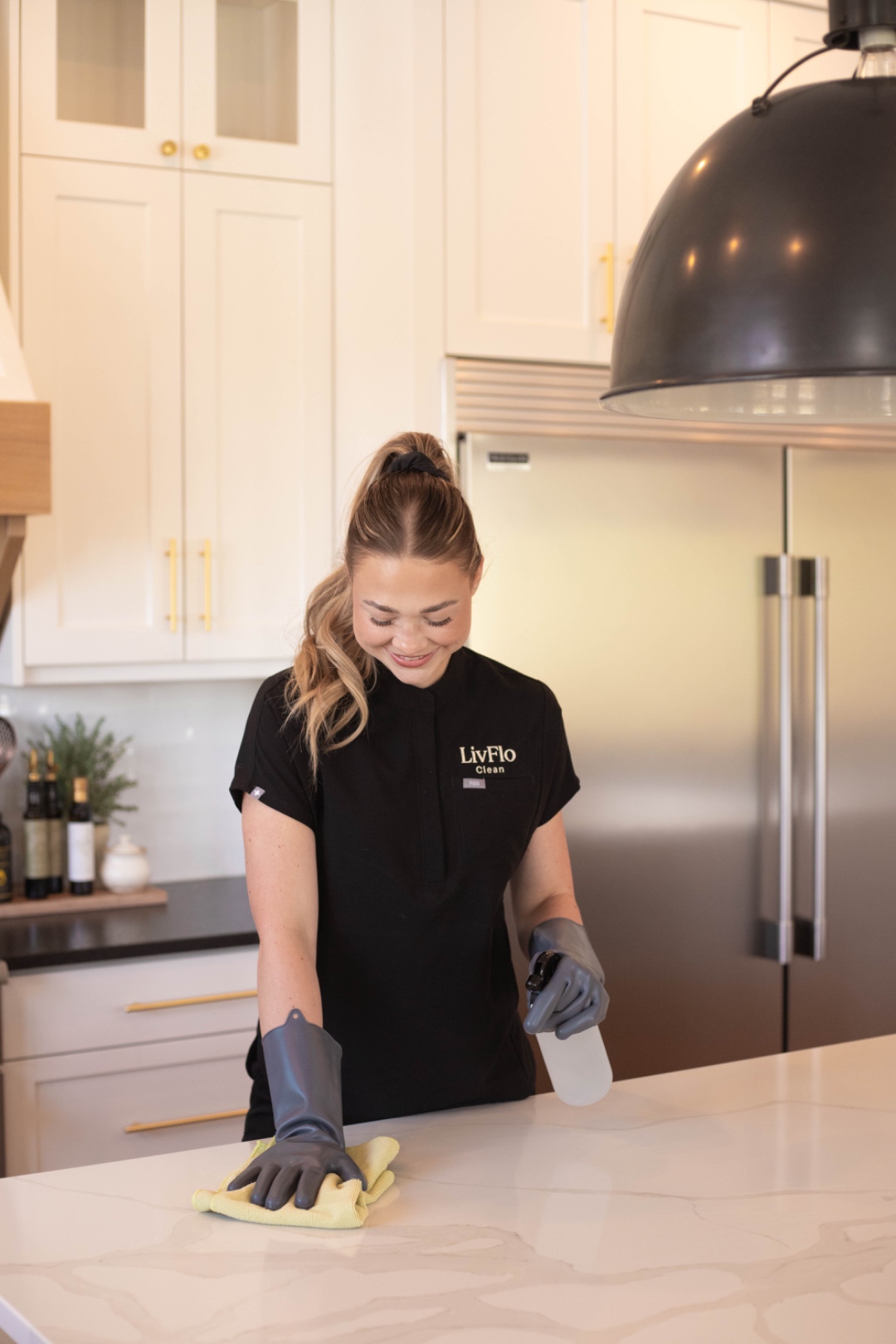 A LivFlo cleaner wiping down a kitchen counter with pro-grade microfiber.